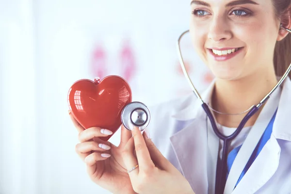 Lekarz z stetoskopem badający czerwone serce, wyizolowany na białym — Zdjęcie stockowe