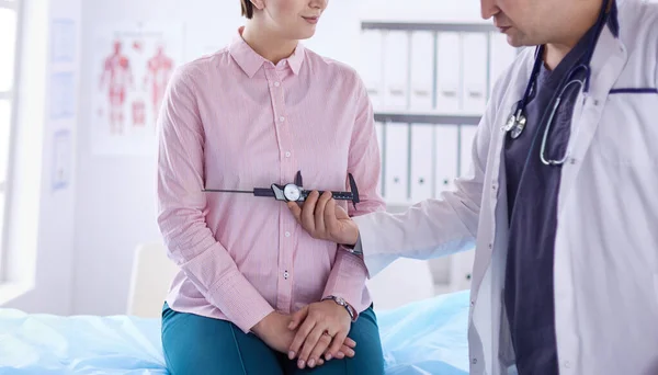 Врач показывает молодому пациенту ее грудь в его кабинете в больнице — стоковое фото
