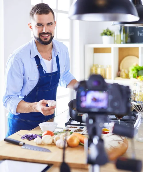 Mutfak arka planında poşet dolusu erzak tutan adam. Alışveriş ve sağlıklı gıda konsepti — Stok fotoğraf