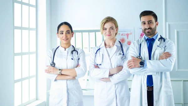 Un team di medici di successo sta guardando la fotocamera e sorridendo mentre si trova in ospedale — Foto Stock