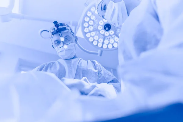 Homem cirurgião no trabalho na sala de cirurgia — Fotografia de Stock