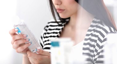 alışveriş - süpermarkette şampuan şişesi tutan genç kadın