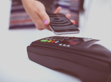 Müşteri ile smartphone Nfc teknolojisi kullanılarak dükkanda ödüyor. NFC teknolojisi. Müşteri ödeme