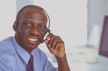 Kulaklıklı Afro-Amerikan işadamı laptopuyla çalışıyor.