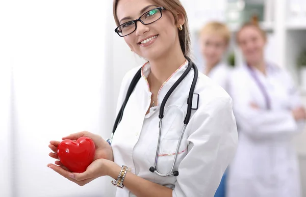 A female doctor holding a heart, isolated on white background — Stock Photo, Image