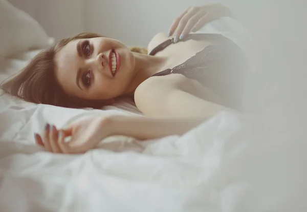 Sexy modieuze vrouw op het bed — Stockfoto