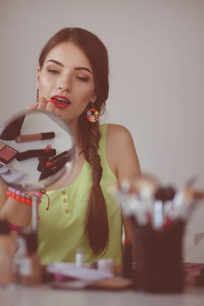 Joven hermosa mujer haciendo maquillaje cerca del espejo — Foto de Stock