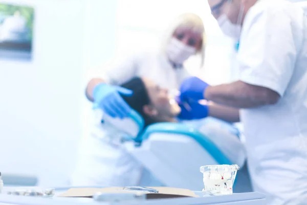 Zahnarzt und seine Assistentin bei einer gründlichen Untersuchung — Stockfoto