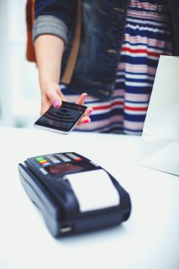 Müşteri ile smartphone Nfc teknolojisi kullanılarak dükkanda ödüyor. NFC teknolojisi. Müşteri ödeme