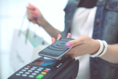 Müşteri ile smartphone Nfc teknolojisi kullanılarak dükkanda ödüyor. NFC teknolojisi. Müşteri ödeme