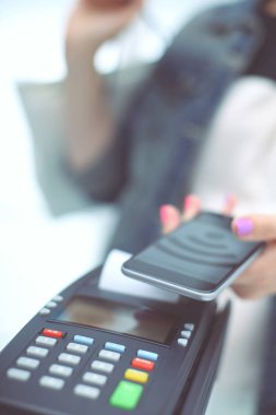Müşteri ile smartphone Nfc teknolojisi kullanılarak dükkanda ödüyor. NFC teknolojisi. Müşteri ödeme