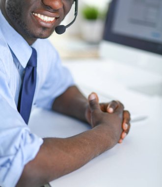 Kulaklıklı Afro-Amerikan işadamı laptopuyla çalışıyor.