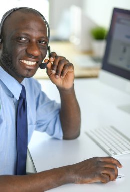 Kulaklıklı Afro-Amerikan işadamı laptopuyla çalışıyor.