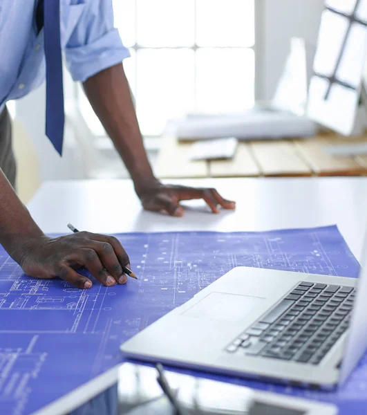 Arquitecto afroamericano trabajando con computadoras y planos en la oficina —  Fotos de Stock