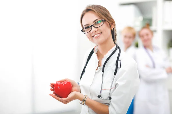 Uma médica feminina segurando um coração, isolado em fundo branco — Fotografia de Stock