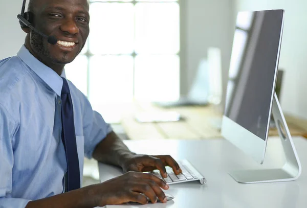 Homme d'affaires afro-américain sur casque de travail sur son ordinateur portable — Photo