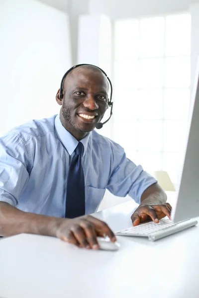 Homme d'affaires afro-américain sur casque de travail sur son ordinateur portable — Photo