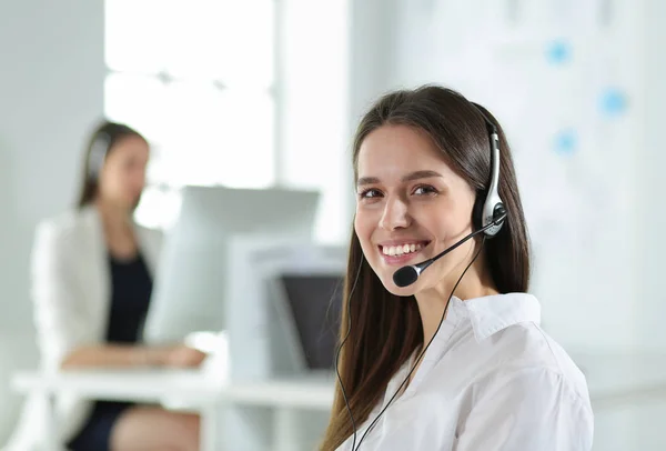 Uomo d'affari sorridente o operatore helpline con auricolare e computer in ufficio — Foto Stock