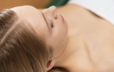 Spa salonunda güzel bir kadının resmi.
