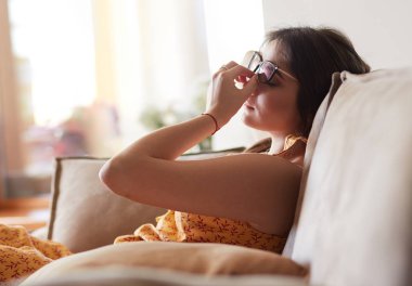 Evdeki modern bir kanepede oturan rahat kadın.