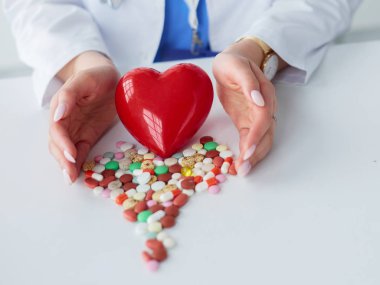 Masada kırmızı kalbi ve steteskopu olan kardiyolog.