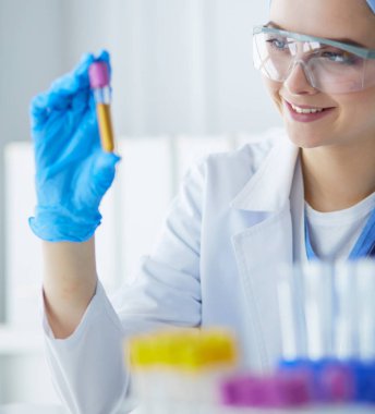 Laboratuvarda sıvı yeşil çözeltiye bakan bir tıbbi veya bilimsel araştırmacı ya da doktor