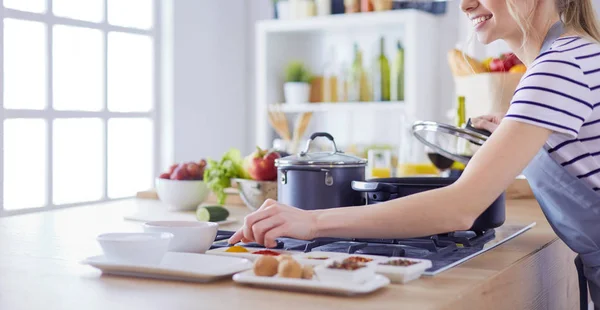 Schöne junge Frau kocht zu Hause in der Küche — Stockfoto