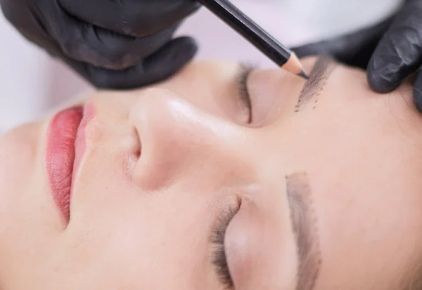 Cosmetologist applying permanent make up on eyebrows — Stock Photo, Image