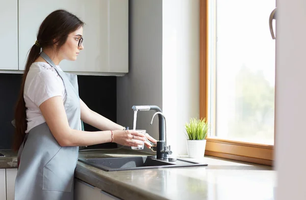 Vrouw handen vullen van het glas water — Stockfoto