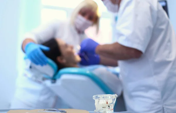 Tandläkare man med patient kvinna på kliniken — Stockfoto