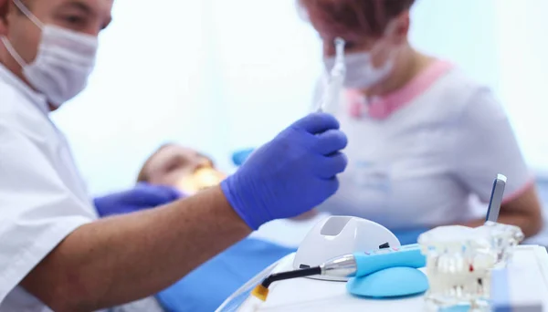 Portret van een tandarts die tanden van jonge vrouw patiënt behandelt — Stockfoto