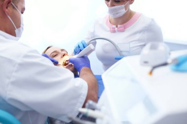 Ağız boşluğuna bakmadan önce dişçisi olan genç bir bayan resmi.