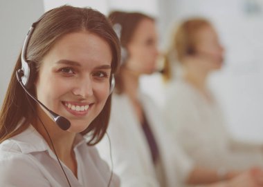 Ofisinde kulaklık ve bilgisayarla gülümseyen iş kadını ya da yardım hattı operatörü