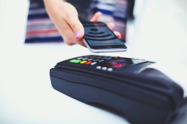 Müşteri ile smartphone Nfc teknolojisi kullanılarak dükkanda ödüyor. NFC teknolojisi. Müşteri ödeme