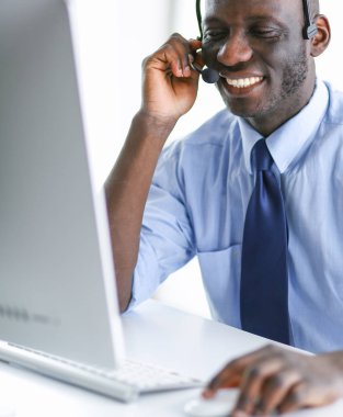 Kulaklıklı Afro-Amerikan işadamı laptopuyla çalışıyor.