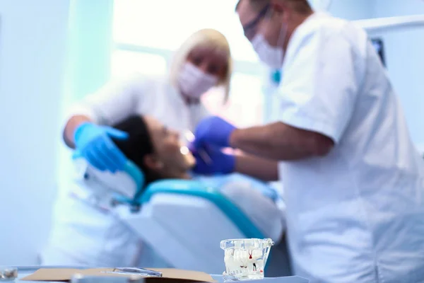 Dentiste homme avec patiente femme en clinique — Photo