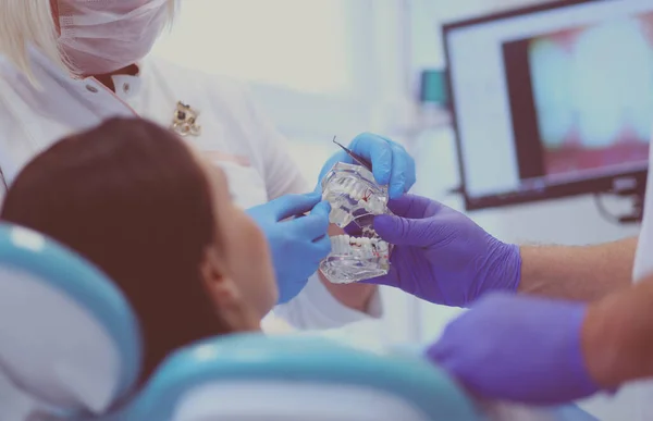 Senior mannelijke tandarts in tandheelkundige kantoor praten met vrouwelijke patiënt en voor te bereiden op de behandeling — Stockfoto