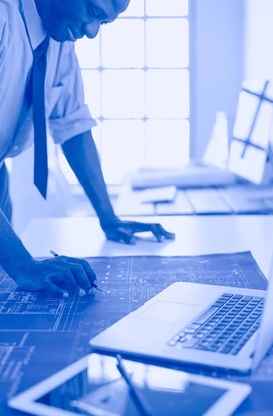 Arquitecto afroamericano trabajando con computadoras y planos en la oficina —  Fotos de Stock