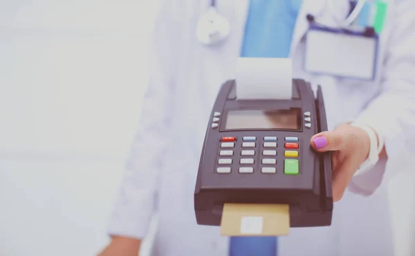 Doctor is holding payment terminal in hands. Paying for health care. Doctor