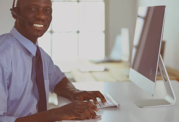 African american businessman on headset working on his laptop — Stock Photo, Image