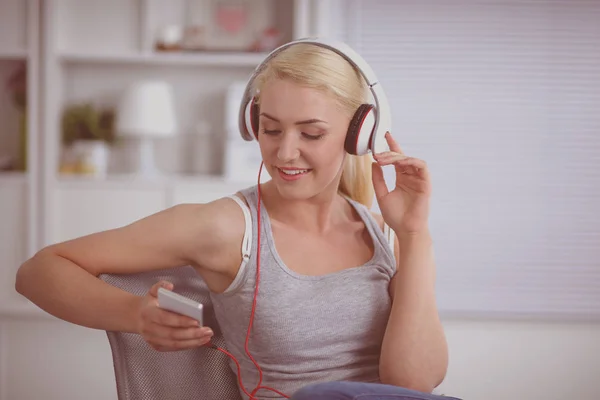 Joven hermosa mujer en casa sentada en el sofá y escuchando música —  Fotos de Stock