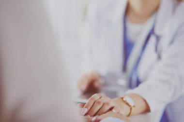 Kadın doktor bir hastaya danışmanlık yapıyor ve tıbbi bilgi ve teşhisi açıklıyor.