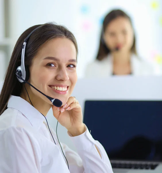 Mujer de negocios sonriente u operador de línea de ayuda con auriculares y computadora en la oficina — Foto de Stock