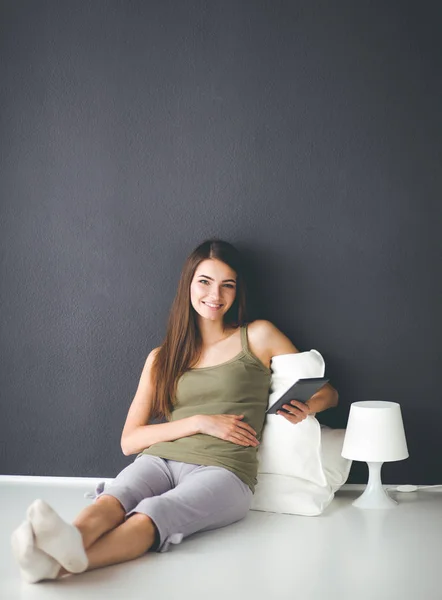 Žena sedící na podlaze pomocí digitálního tabletu — Stock fotografie