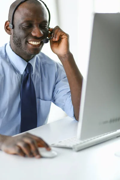 Homme d'affaires afro-américain sur casque de travail sur son ordinateur portable — Photo