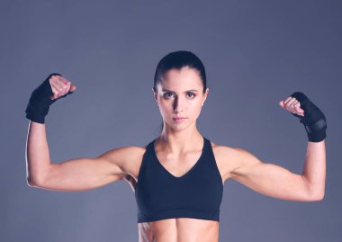 Spor giyim siyah arka plan karşı poz kas genç kadın.