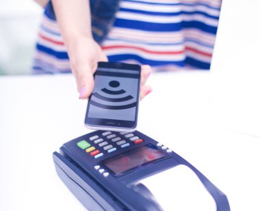 Müşteri ile smartphone Nfc teknolojisi kullanılarak dükkanda ödüyor. NFC teknolojisi. Müşteri ödeme
