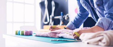 Moda tasarımcısı kadın stüdyoda tasarımları üzerinde çalışıyor.