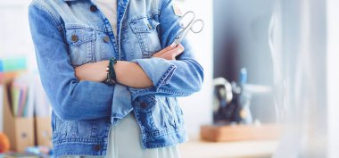 Moda tasarımcısı kadın stüdyoda tasarımları üzerinde çalışıyor.