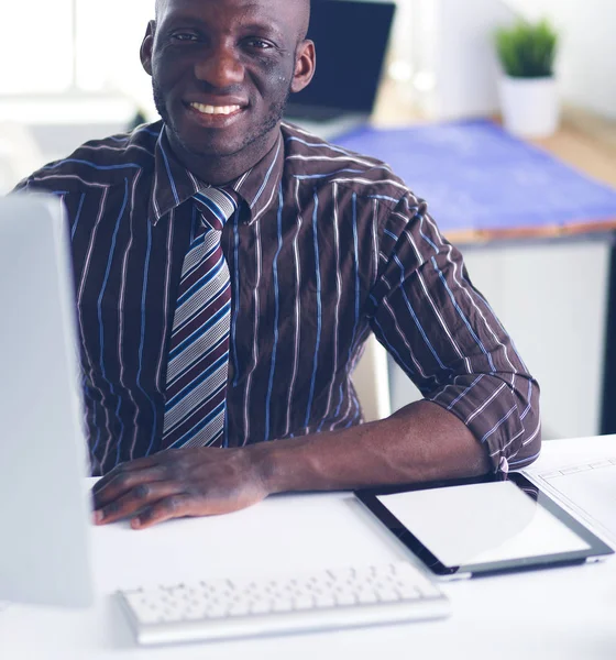 Beau Afro-Américain homme d'affaires en costume classique utilise un ordinateur portable et souriant tout en travaillant au bureau — Photo